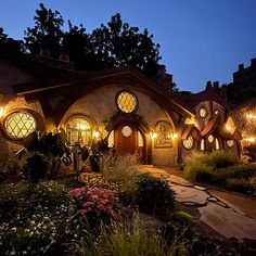 an exterior view of a hobbot house at night with lights on the windows