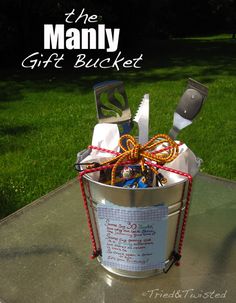 a bucket filled with assorted items sitting on top of a metal table in the grass