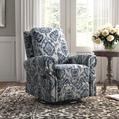 a blue and white chair sitting on top of a rug in front of a window