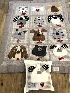 a quilted blanket with dogs on it and two pillows in the shape of hearts