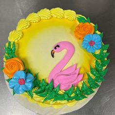 a cake decorated with flowers and a pink flamingo