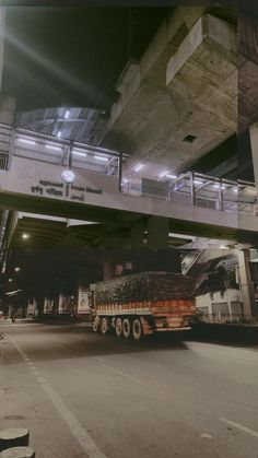 a large truck driving under an overpass at night