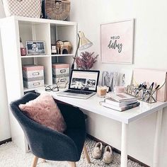 a white desk topped with a laptop computer next to a book shelf filled with books