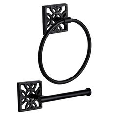 a black toilet paper holder with an ornate design on it's side and a round towel ring in the middle