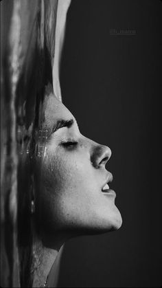 a black and white photo of a woman's face with her hair blowing in the wind