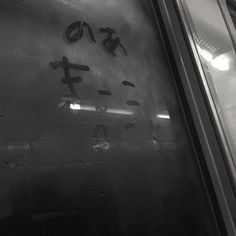 an airplane door with writing on it and symbols painted on the glass window in black and white