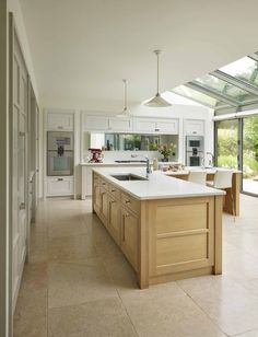 a large kitchen with an island in the middle and lots of windows on both sides