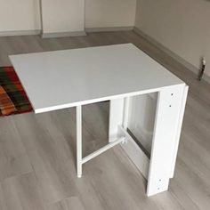 a white table sitting on top of a hard wood floor