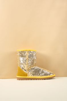 Spice up your shoe game with Smaibulun Ugg's Dallas Glam Sequin Shearling Boots! The perfect blend of style and comfort, these boots feature playful yellow glam sequins and cozy shearling lining. Who says ugg footwear has to be boring? (No one, that's who!) 1'' heel 7.6'' shaft 15.8'' circumference Pull-on Suede upper & Man-made sequins Faux fur lining EVA sole Ugg Golden Glow Sandal, Rhinestone Ugg Boots, Glitter Ugg Boots For Woman, Sequin Ugg Boots, Betsey Johnson Gold Boots, Reindeer Headband, Shearling Boots, Eva Sole, Ugg Shoes