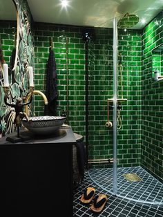 a green tiled bathroom with a shower and sink