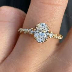 a woman's hand with a diamond ring on top of her finger and an engagement band