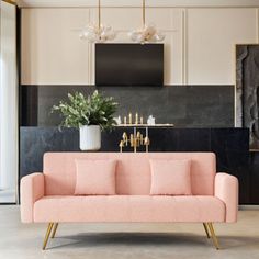 a living room with a pink couch and black wall behind the couch is a painting