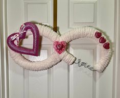 a heart shaped wreath hanging on the front door