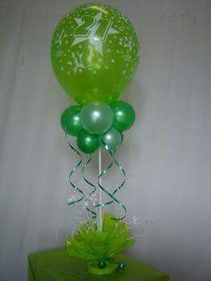 green balloons and streamers in front of a white backdrop