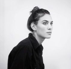 a black and white photo of a woman with her hair in a high pony tail