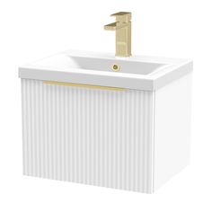 a white sink with a gold faucet on top