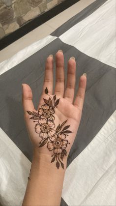 a woman's hand with a flower tattoo on it