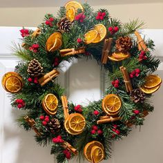 a christmas wreath with oranges, cinnamon and pine cones