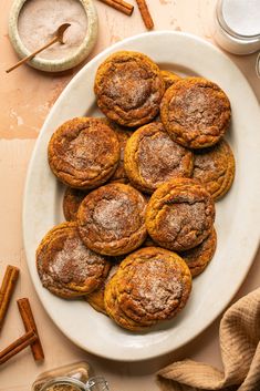 a white plate topped with cookies next to cinnamon sticks