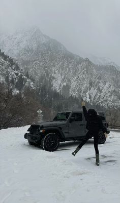 a person standing next to a truck in the snow