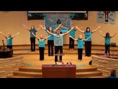 a group of people standing on top of a stage with their hands in the air