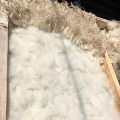 a pile of white fur sitting on top of a wooden floor