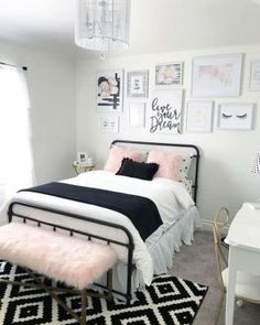 a white and black bedroom with pictures on the wall