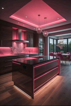 a modern kitchen with pink lighting on the ceiling and wooden flooring, along with an island