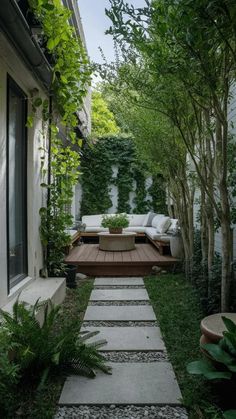 an outdoor patio with wooden steps leading up to the deck and seating area, surrounded by greenery