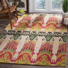 a colorful rug is on the floor in front of a door with a potted plant