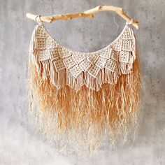 a crocheted macrame with fringes hanging on a branch