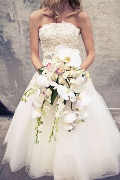 a woman in a wedding dress holding a bouquet