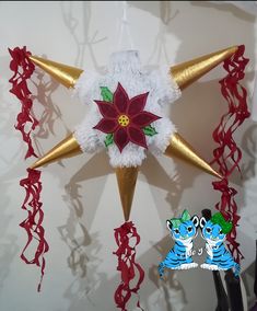 a christmas star decoration with poinsettia and red streamers