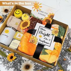 an open box with sunflowers, soap and other items in it on a table