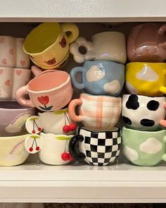 a shelf filled with lots of different colored coffee cups and saucers on top of each other