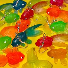 many different colored fish key chains on a yellow surface