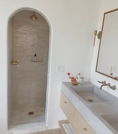 a bathroom with two sinks and a large mirror on the wall next to the shower