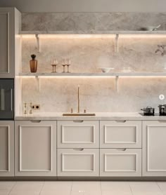 a modern kitchen with white cabinets and marble counter tops, built in shelving above the sink