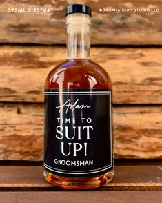 a bottle of groomsman's time to suit up syrup on a wooden table