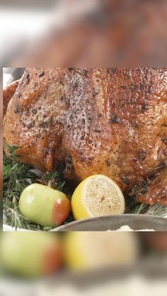 a large piece of meat sitting on top of a plate next to fruit and vegetables