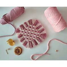 yarn, oranges and other craft supplies are laid out on a table together to be used as wall hangings