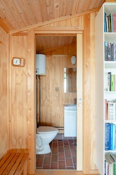 there is a toilet in the bathroom with books on the shelves next to it and a bookcase behind it