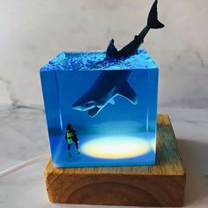 a light that is on top of a wooden block with a shark in the water