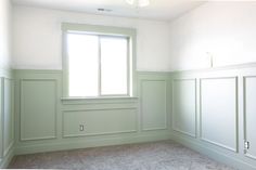 an empty room with white walls and green trim