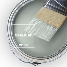 a paint can with a brush in it and the words mountain falls painted on it