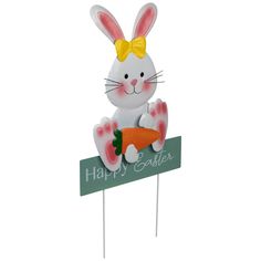 a white rabbit holding a carrot on top of a sign