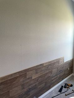 a room that is being remodeled with wood paneling on the wall and tools in front of it