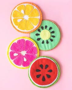 three slices of fruit are shown on a pink surface