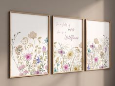 three framed art pieces with flowers on them in a living room wall setting, one is pink and the other is white