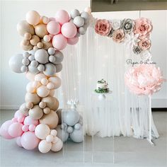 the balloon arch is decorated with flowers and balloons